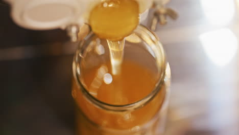 fresh sweet golden fragrant honey pouring into jar