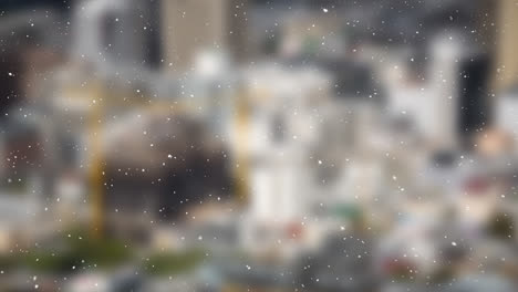 Snow-particles-falling-over-blurred-view-of-cityscape-in-background