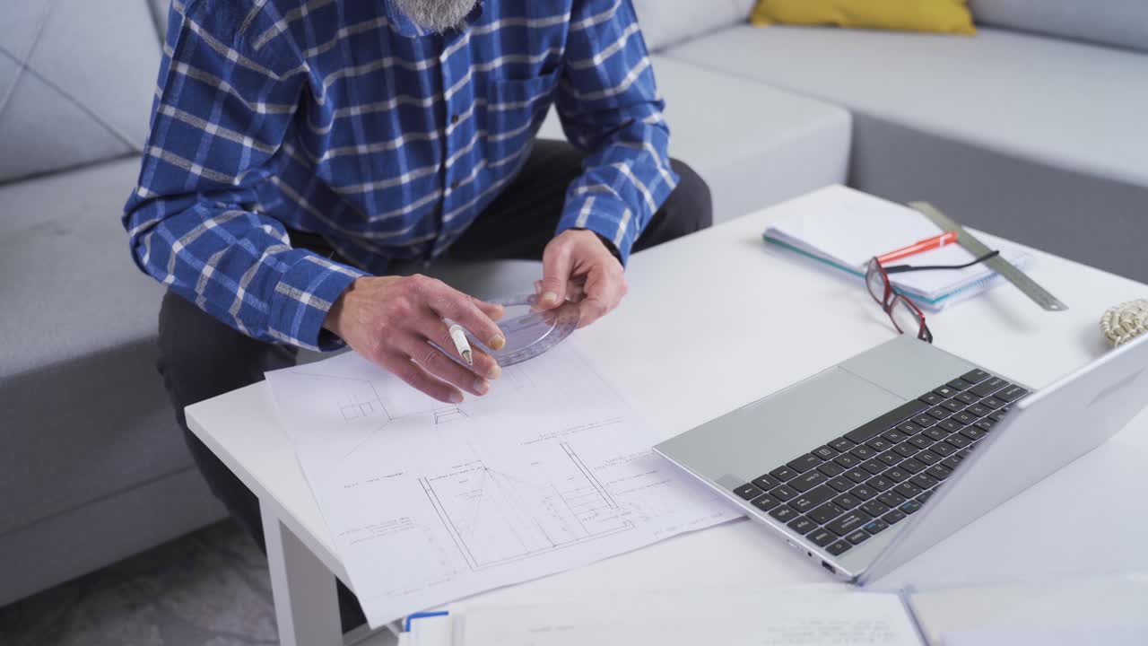 Mature engineer man working on project from home.