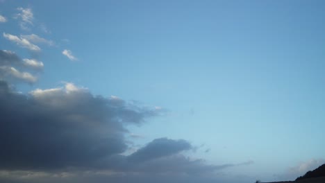 hyperlapse of clouds rushing past as the sun is about to rise, blue hour, light reflecting on the clouds
