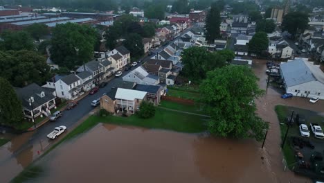 flooded yards and garden of single family house in american town at dawn. aftermath scene after hurricane at night. aerial top down shot. dirty water flooding houses