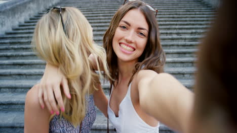 two friends taking a selfie on a staircase in italy