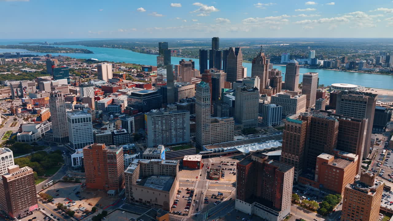 Numerous parking-lots with parked vehicle in the downtown of Detroit, Michigan, USA. Aerial perspective on the Detroit River flowing through the scenery. Detroit, USA, 28 July 2025: