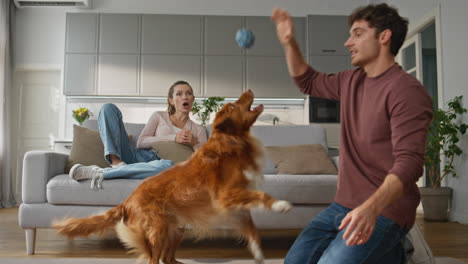 happy guy teaching pet in home close up. smiling woman looking on dog training