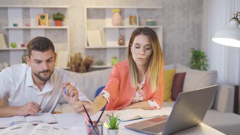 Los-Estudiantes-Universitarios-Trabajan-En-Casa-Con-Una-Computadora-Portátil-Y-Miran-Libros.