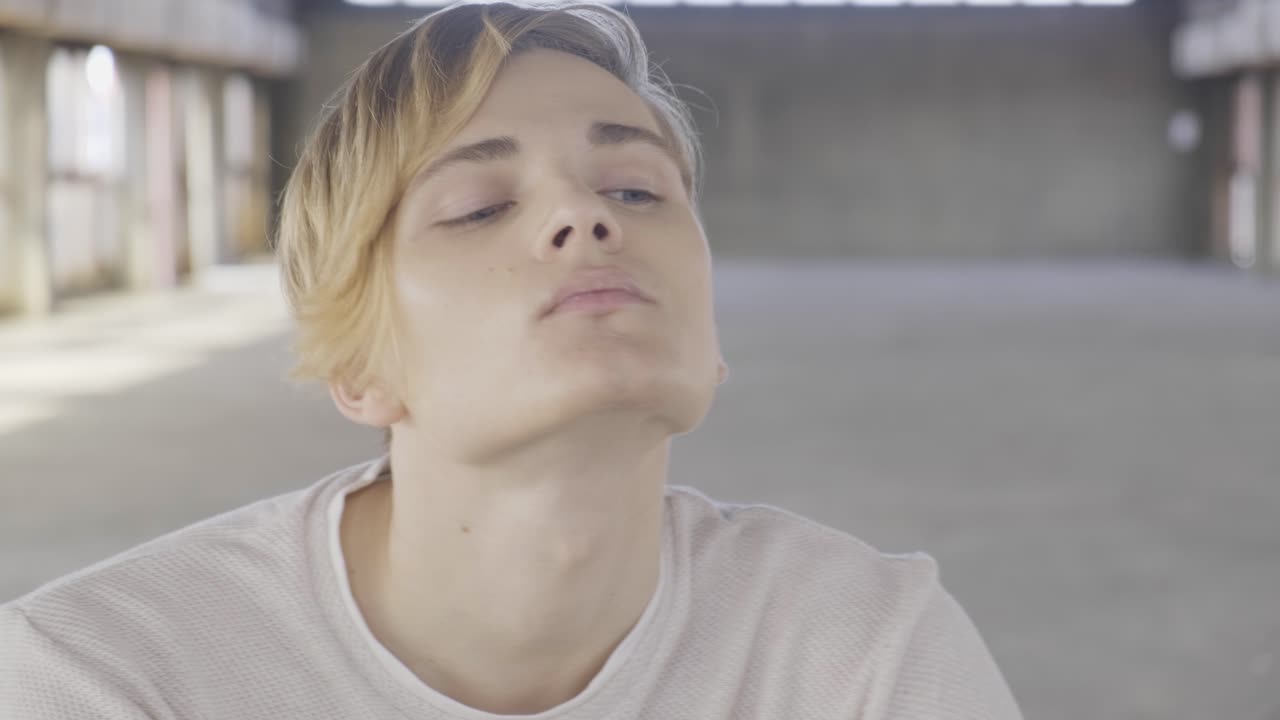 joven hombre de moda sentado en una silla en el pasillo