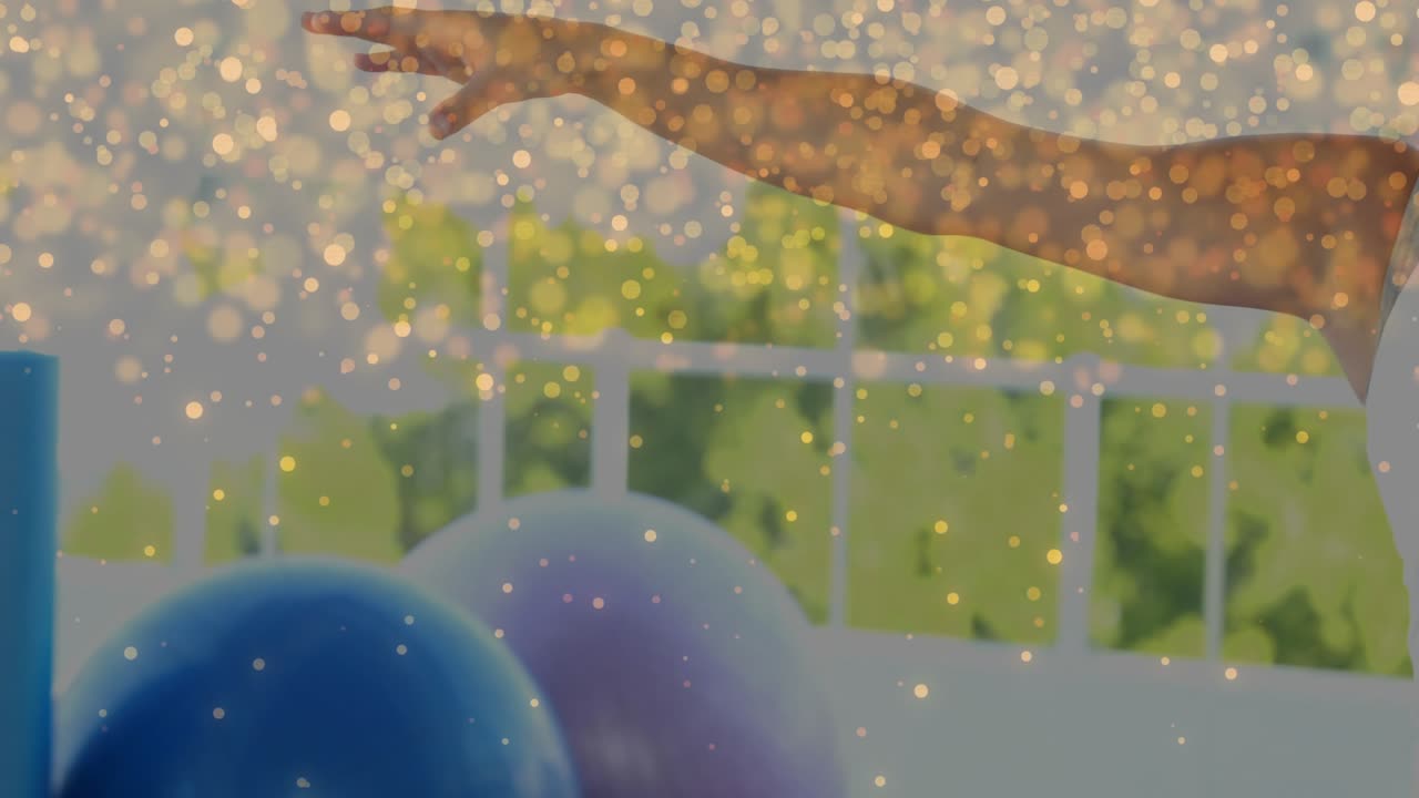 Woman pointing left, starting T-pose on porch with balloons, gold sparkle covering face for fitness