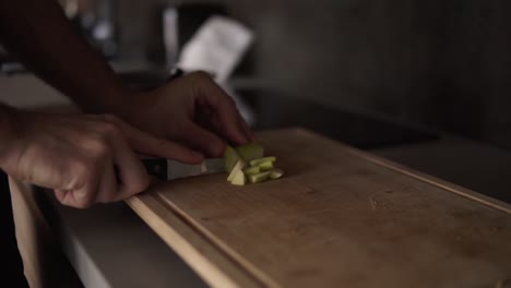 un hombre limpia las manos corta manzanas verdes y jugosas con un cuchillo para cocinar