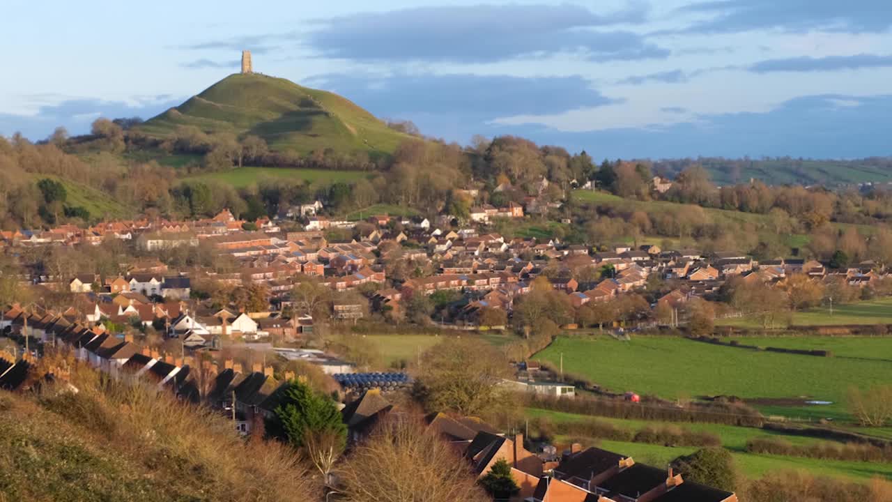 Historic St Michael's Tor in Glastonbury town, Somerset England with rows of beautiful red brick houses in rural countryside county