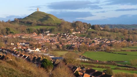 Historic-St-Michael's-Tor-in-Glastonbury-town,-Somerset-England-with-rows-of-beautiful-red-brick-houses-in-rural-countryside-county