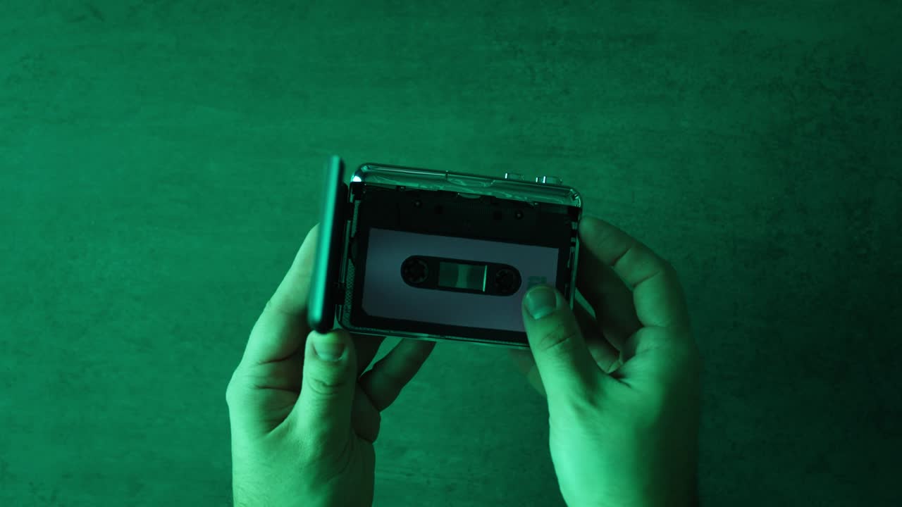 Hands holding an open cassette tape player