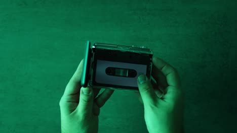 manos sosteniendo un reproductor de cintas de cassette abierto