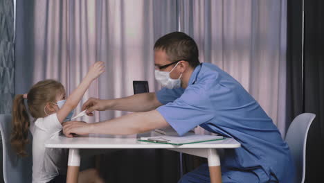 pediatrician-and-child-sit-at-table