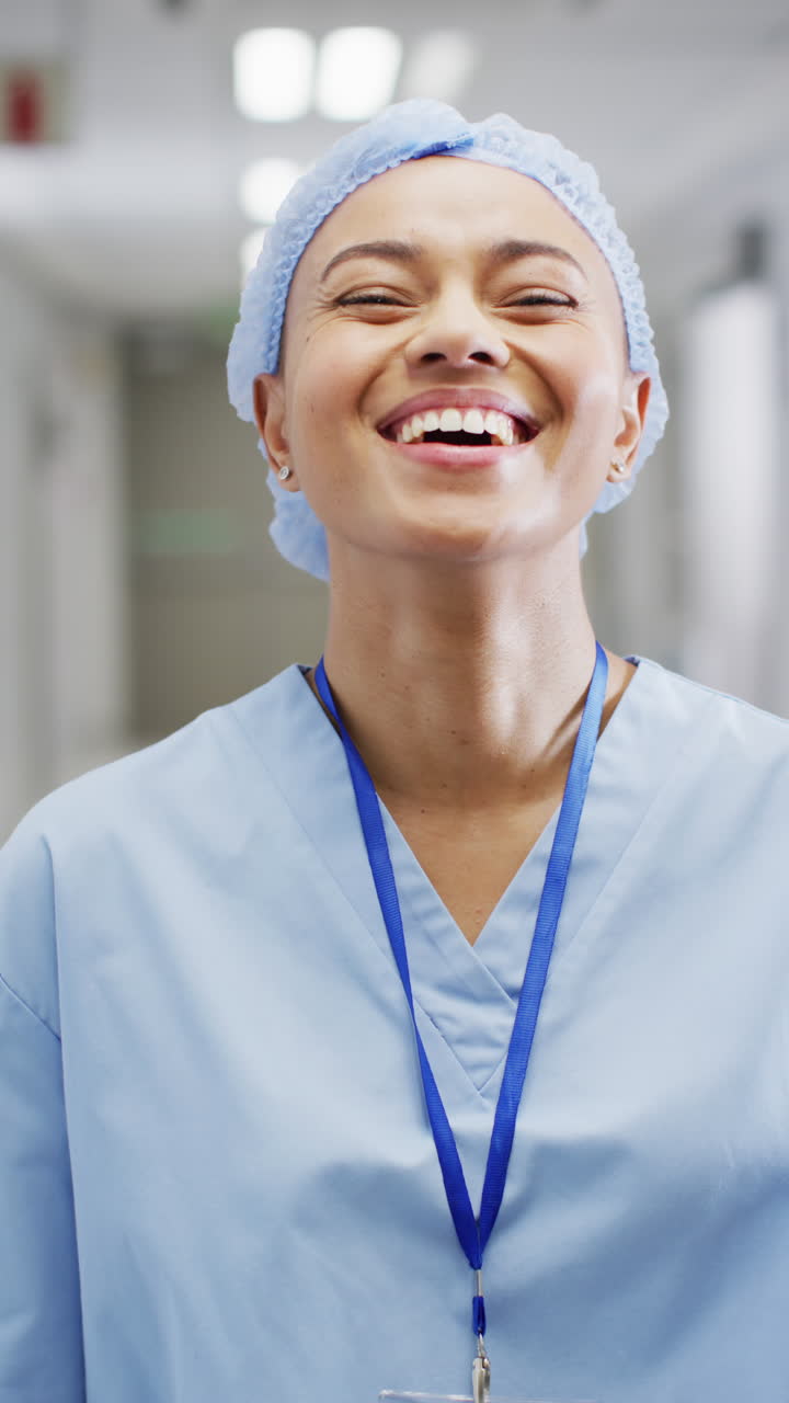 Vertical video of portrait of happy biracial female doctor