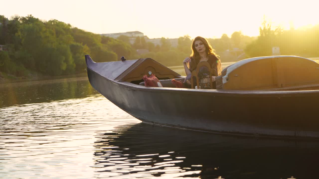 beautiful woman in a dress is sitting and posing on a gondola in Venice