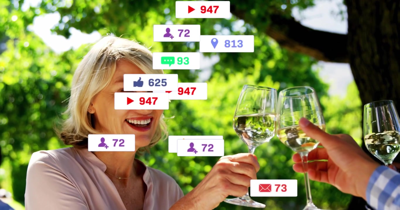 Kvinne hever glasset, sosiale medier-ikoner svulmer over ansikt og glass, deretter skåler hun med en venn.