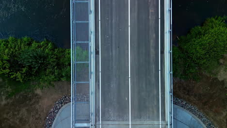 Drone-overhead-view-of-a-bridge-built-over-a-river,-directly-above-aerial-perspective