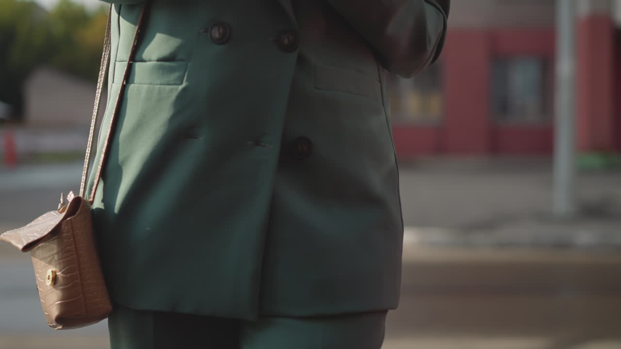 una mujer ocupada se acerca a un coche rojo brillante sosteniendo un teléfono móvil