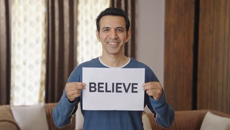 happy indian man holding believe banner