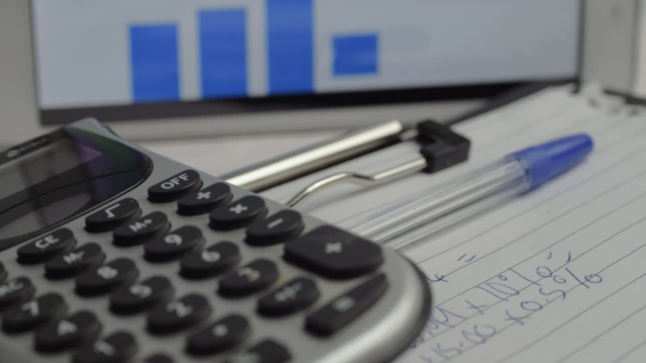 Close up of calculator with financial graph in background in office
