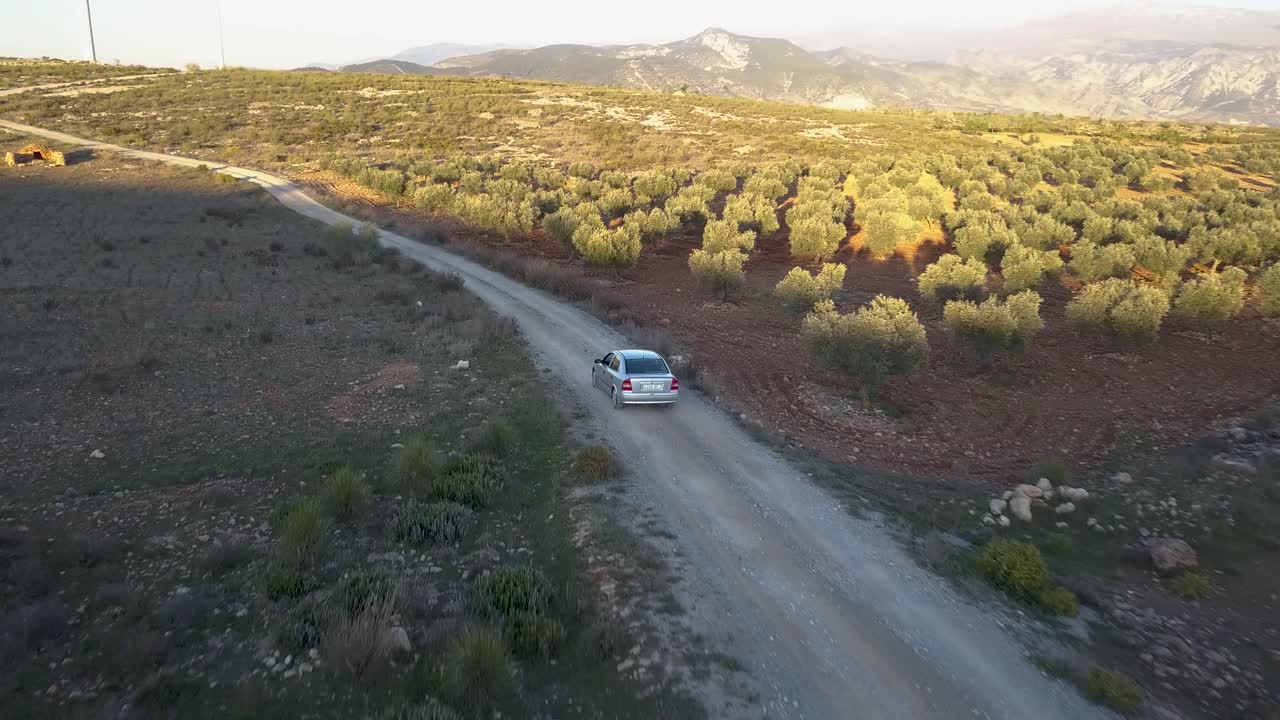 Ripresa aerea in tracking che segue un'auto in campagna.