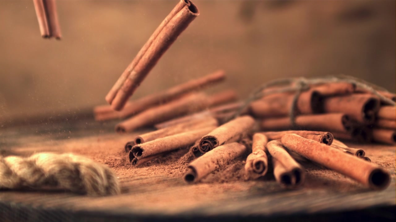 Paus de Canela Caindo sobre Canela em Pó em Câmera Lenta