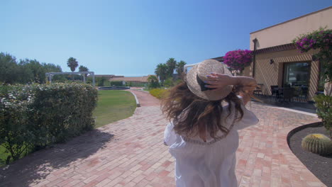 woman in straw hat walking through a garden