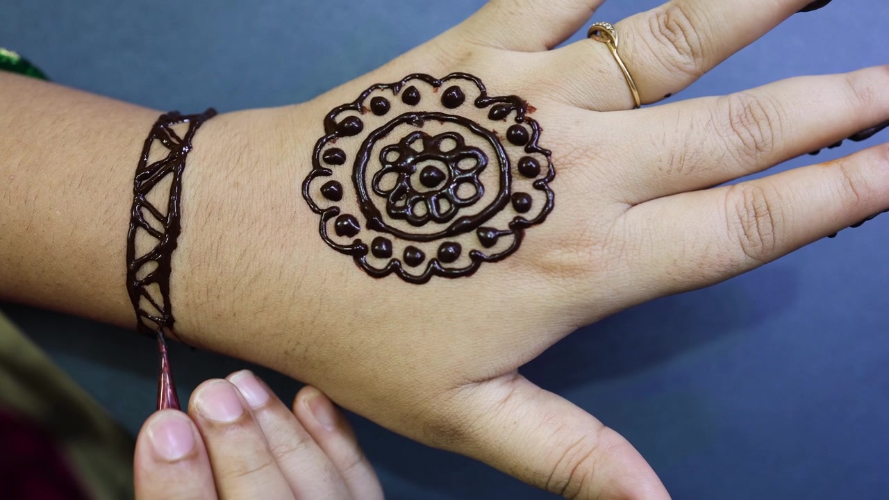 Mano decorata con un fresco disegno Mehndi durante una celebrazione culturale indiana.