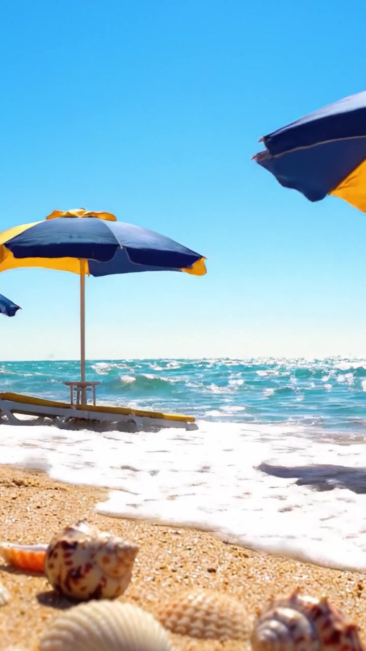 Una rilassante scena da spiaggia con ombrelloni colorati e conchiglie variegate sulla sabbia dorata, sotto un cielo azzurro e limpido con dolci onde oceaniche che si infrangono