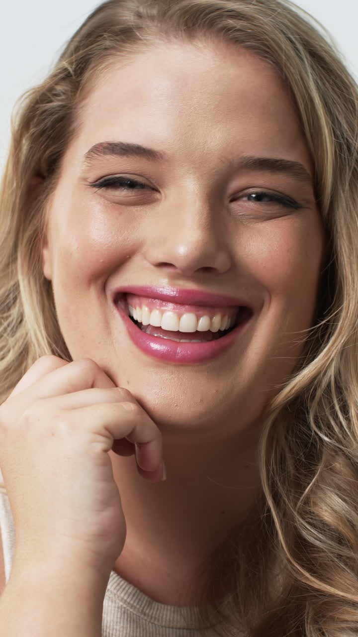 Vertical video: Smiling plus size woman with hand on chin, promoting body positivity and self-confid