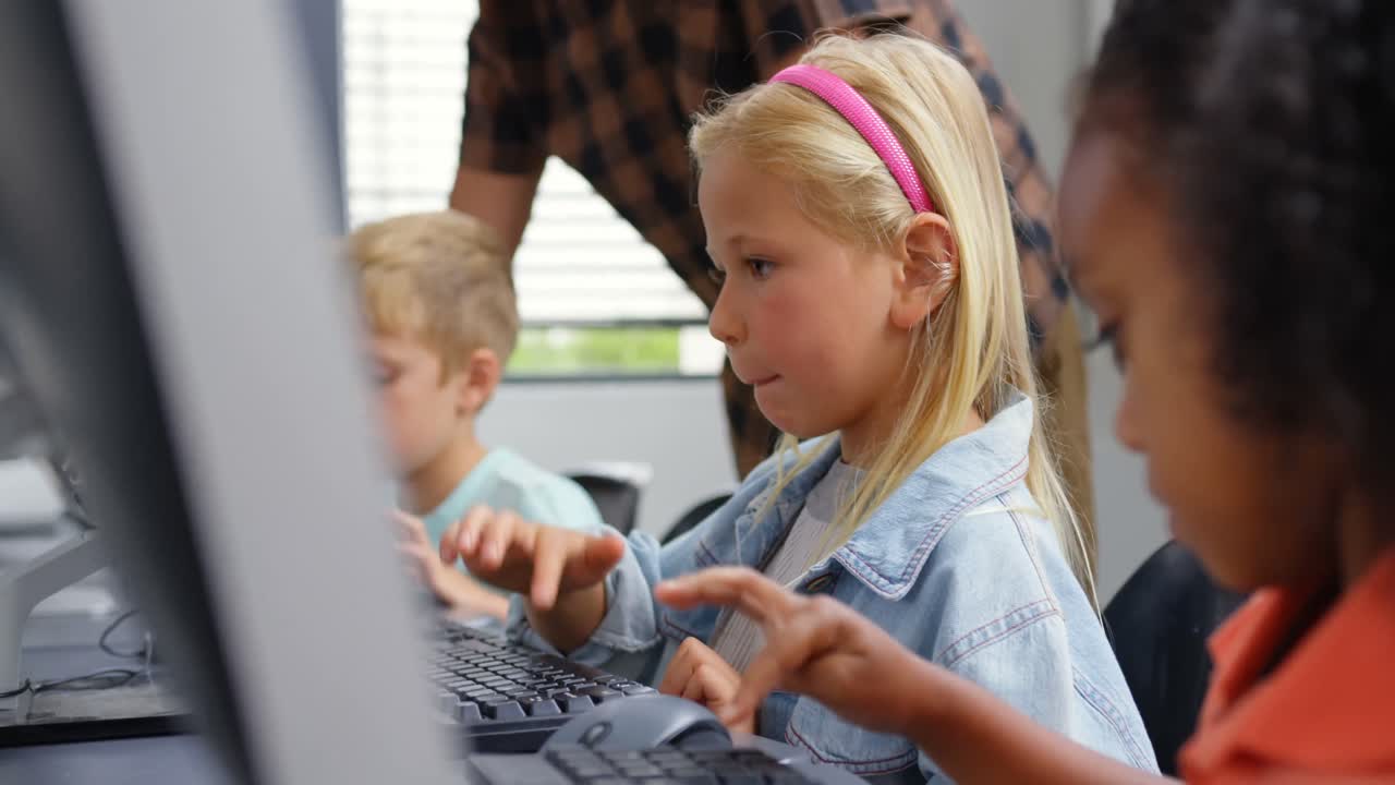 Side view of Caucasian schoolgirl studying on personal computer male teacher teaching schoolkids in