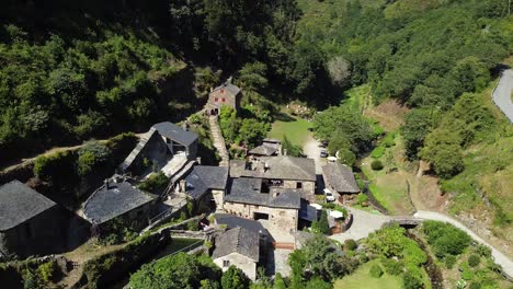 toma aérea, drone volando sobre un pequeño pueblo en el valle de las verdes montañas de asturias, españa