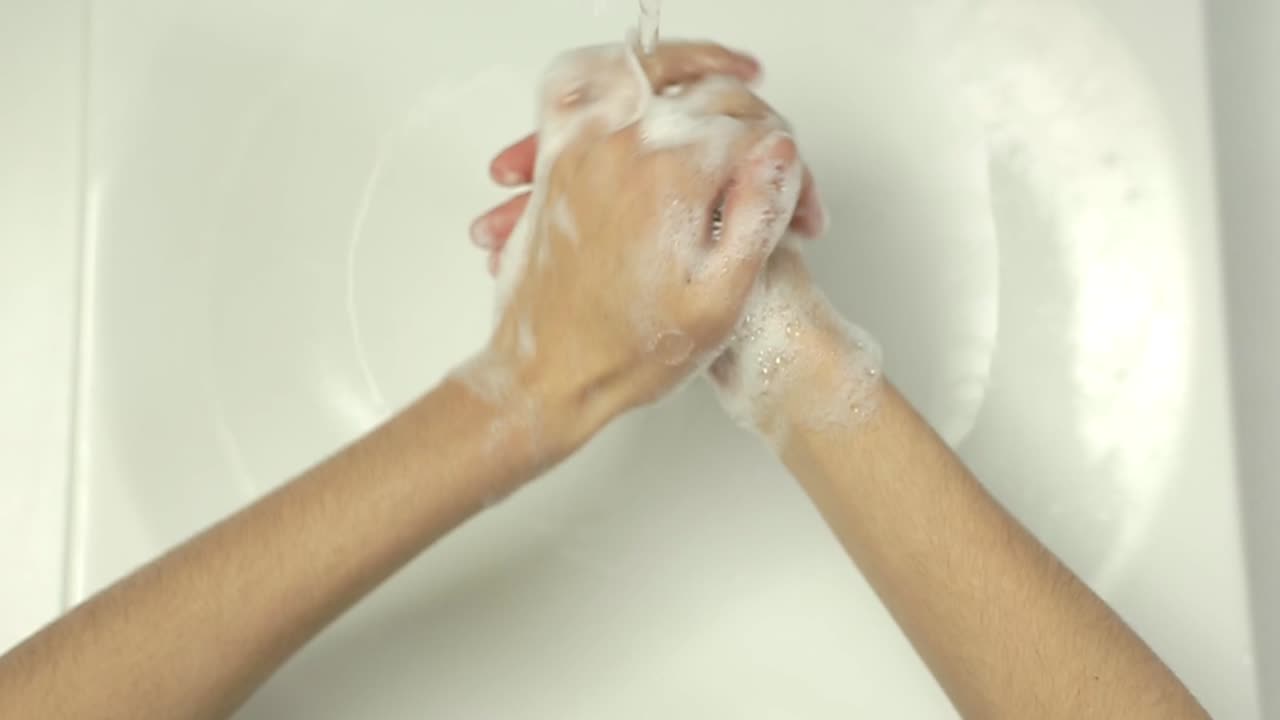 Persona che si lava e asciuga le mani con sapone e asciugamano di carta
