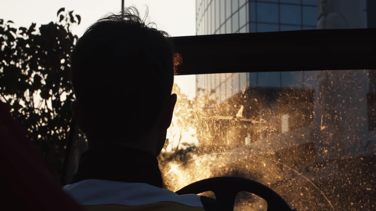 Person driving a car at sunset