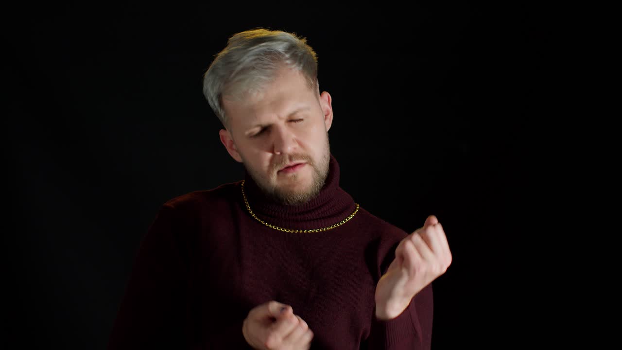 잘생긴 디스코 댄스 남자 음악에 맞춰 춤을 추고, 나이트클럽에서 손을 움직이고 검은 바탕