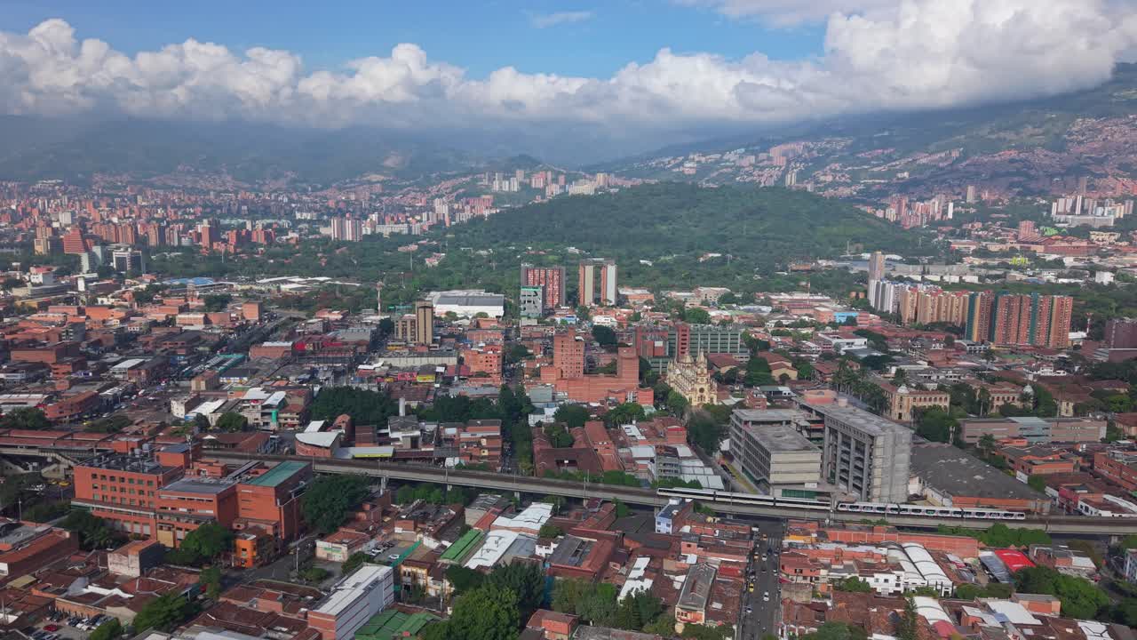 Paisagem urbana panorâmica de Medellín com bonde e montanhas exuberantes.