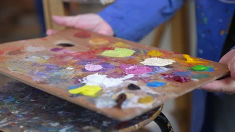 close-up of painters hands taking colour palette to start painting