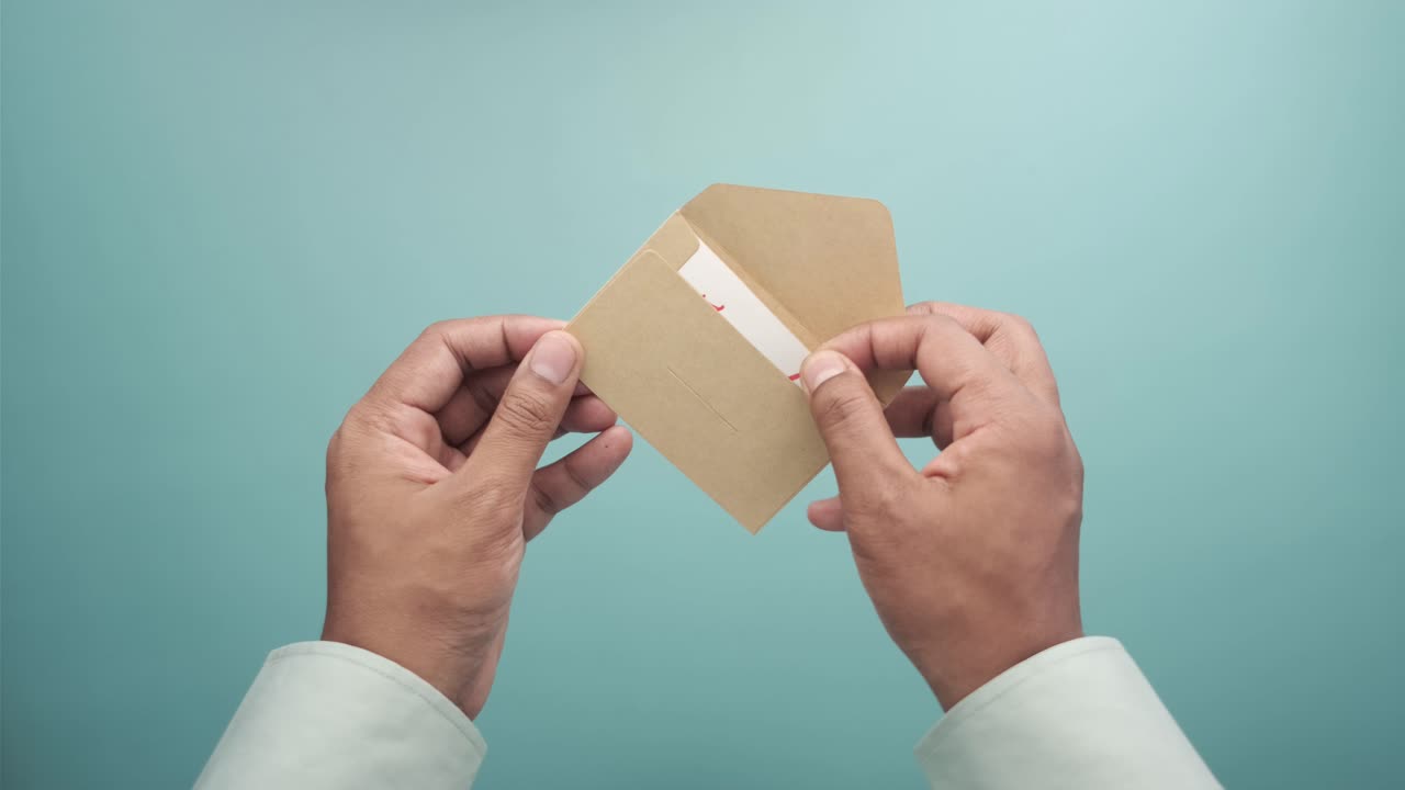 manos con una nota de agradecimiento y un sobre