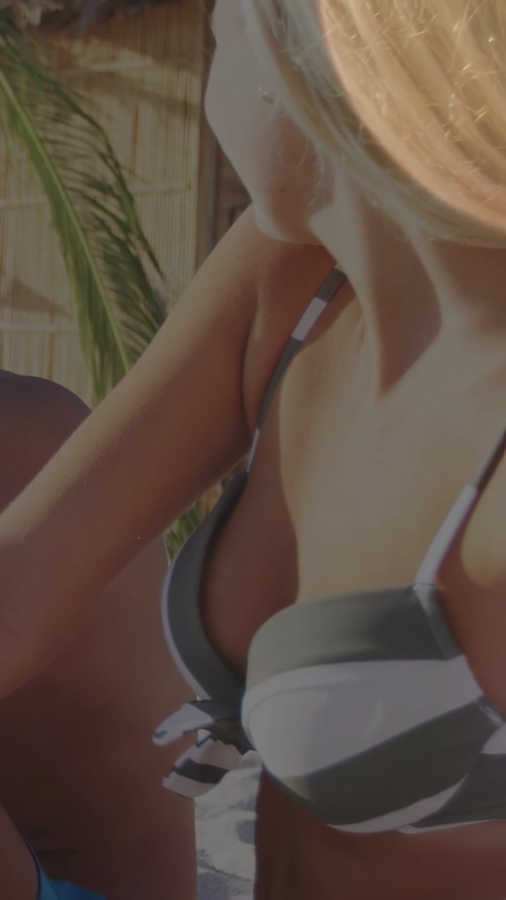 Video verticale: Una donna in bikini si china e si gira verso un uomo, mentre un bagliore solare anima una pubblicità di viaggio.