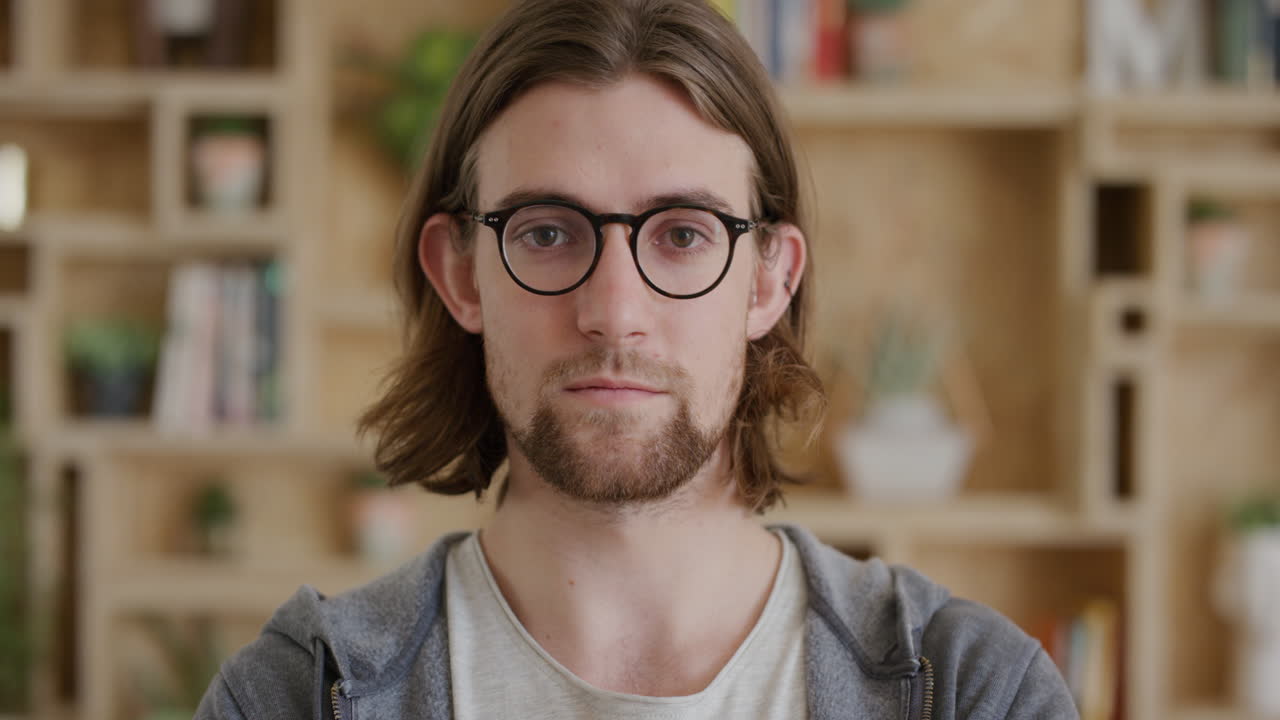 close up portrait of cute young man geek looking serious at camera arms crossed handsome student nerd wearing glasses