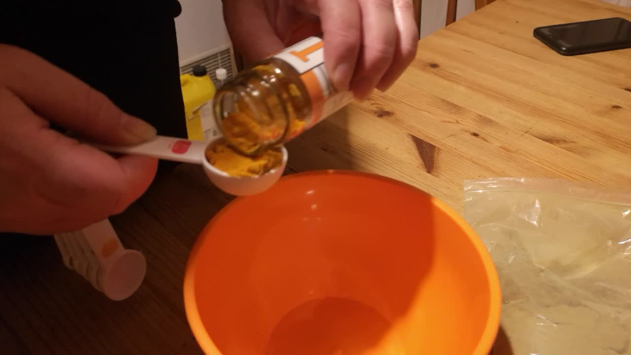 hembra que mide moringa y suplemento de remedio herbal en polvo de cúrcuma en tazón naranja