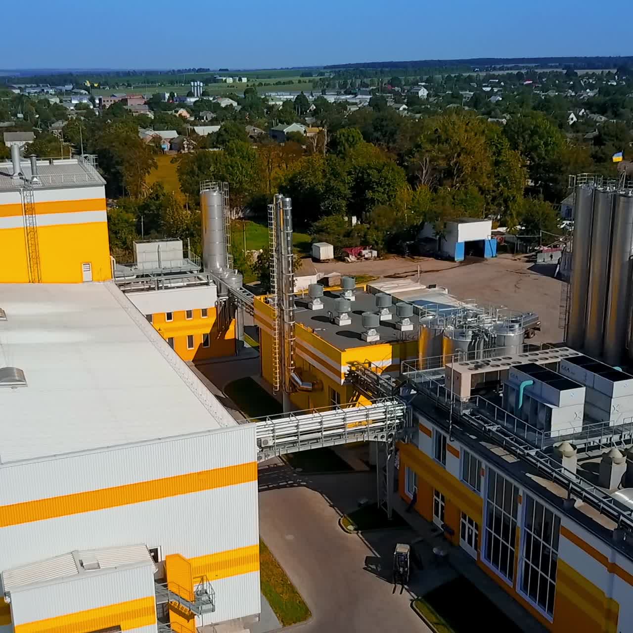 Neat territory of a new industrial plant. Rural area in the exuberant greenery on sunny day. Top view