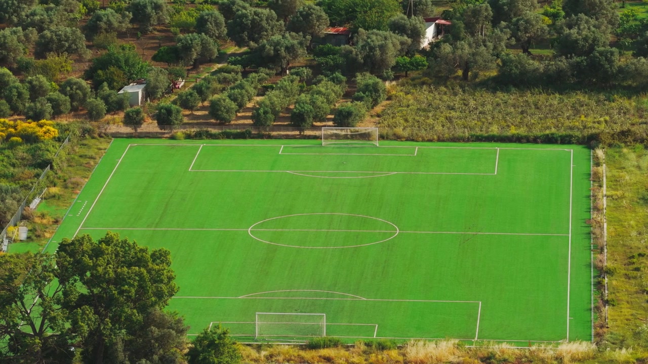Vista aérea de campo de futebol verde vazio em paisagem rural