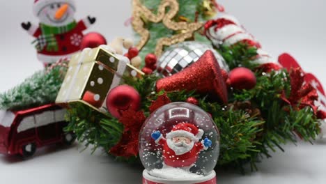 santa claus in a snow-globe, christmas decorations around the christmas tree