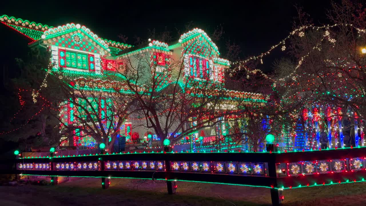 Gingerbread Candy cane lane house vibrant lights home Merry Christmas trees Happy Holidays decoration Highlands Ranch Denver Colorado USA night time bright hanging branch neighborhood left pan motion
