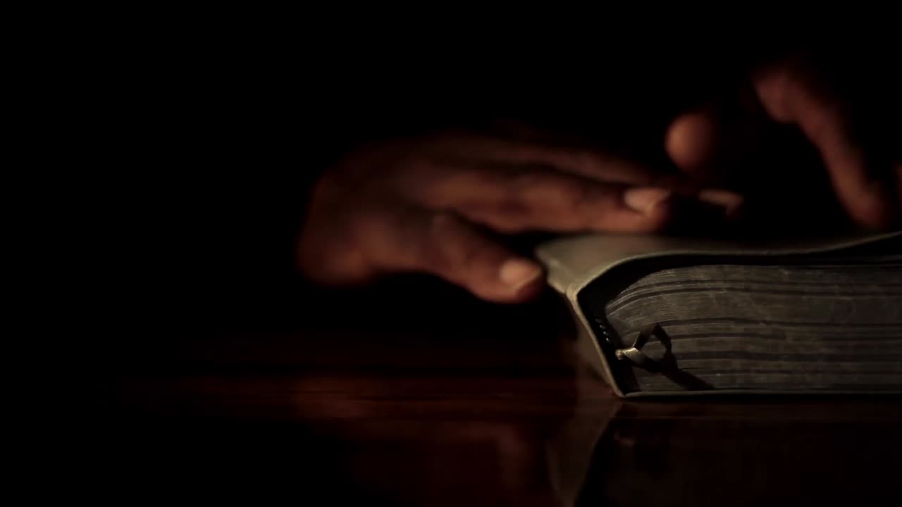 Prière à Dieu, la main sur la bible, sur fond noir avec des personnes – images d'archives-5