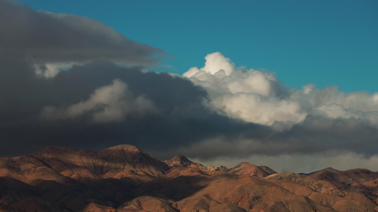 montañas en las fronteras del desierto de mojave con nubes de tormenta en rápido movimiento formándose y rodando sobre los picos escarpados - lapso de tiempo