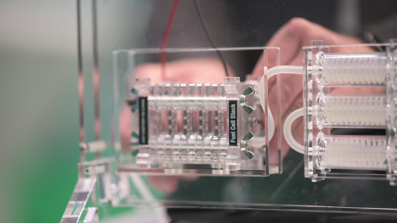 manos conectando una pila de celdas de combustible para generar electricidad a partir de hidrógeno y aire