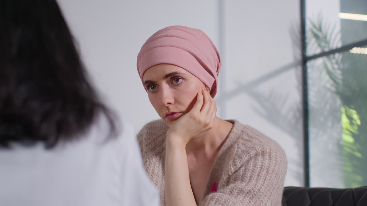 Close Up Of Serious Young Woman Patient Wearing Headscarf Undergoing Chemotherapy Treatment For Breast Cancer Meeting With Oncologist Or Doctor In Hospital 2