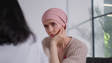 close up of serious young woman patient wearing headscarf undergoing chemotherapy treatment for breast cancer meeting with oncologist or doctor in hospital 2